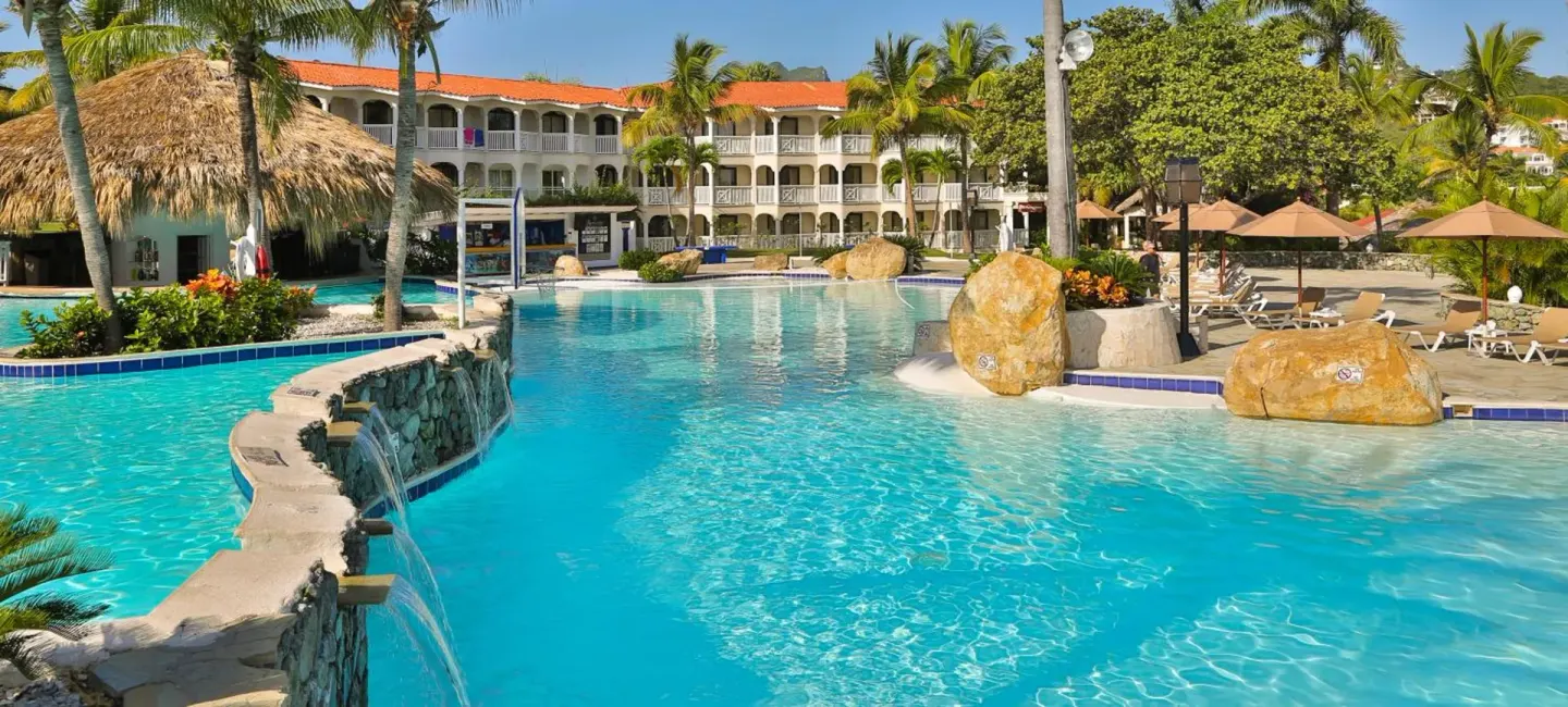 Large resort pool with palm trees and guest buildings at Lifestyle Tropical Beach Resort & Spa.
