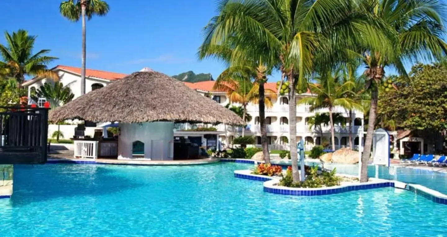 Pool with swim-up palapa bar and palms at Lifestyle Tropical Beach Resort & Spa.