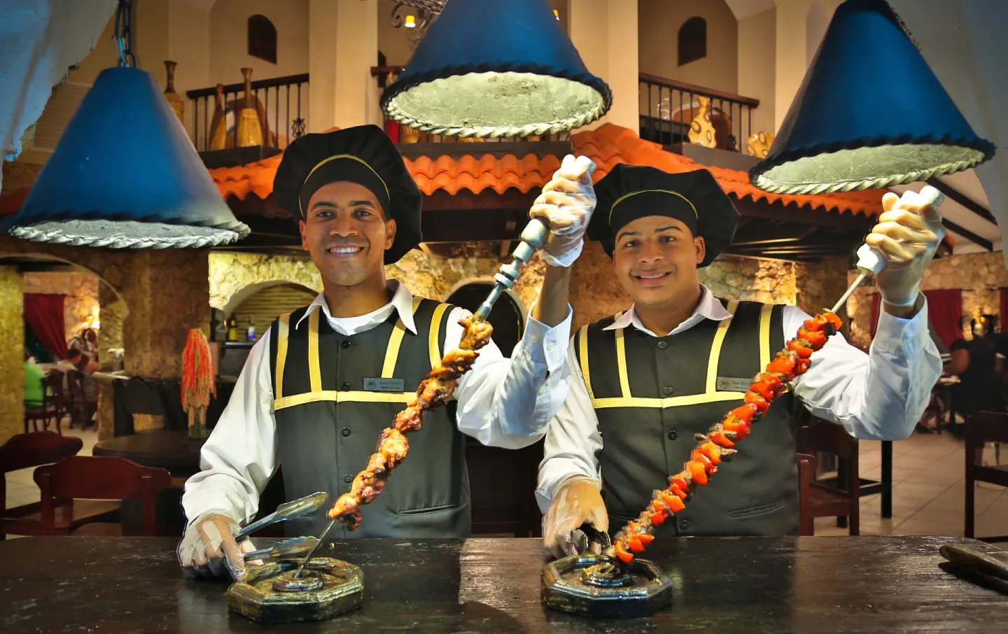 Restaurant staff hold grilled skewers at Lifestyle Tropical Beach Resort & Spa.