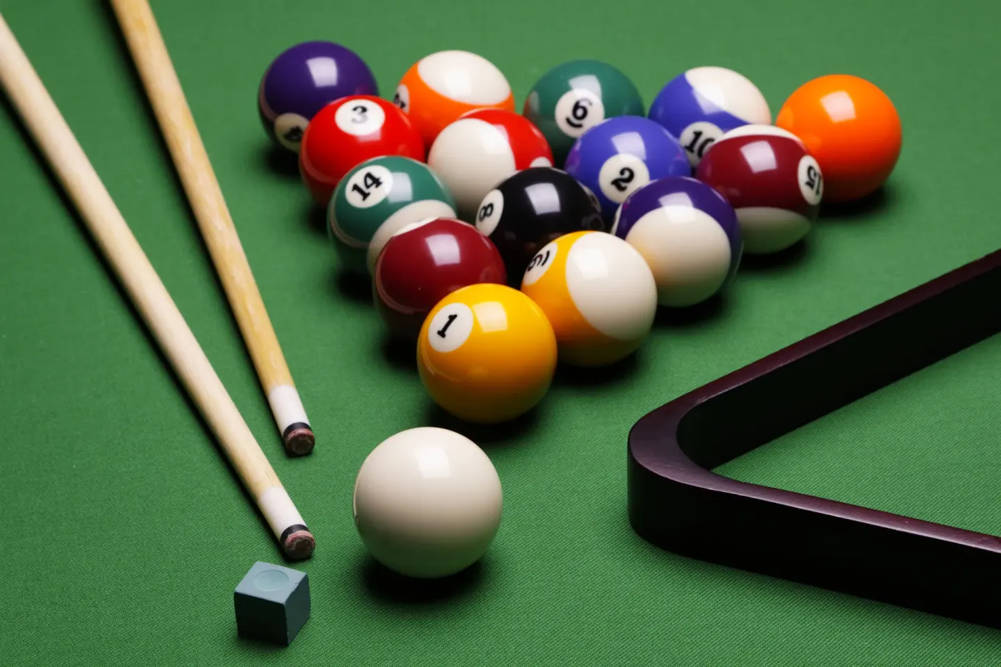 Pool balls, cues, rack, chalk, and green felt on a billiards table at Live Aqua Cancun.