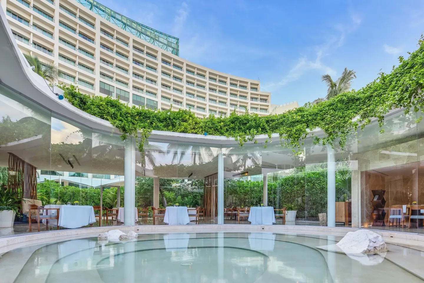 Curved courtyard with reflecting pool and resort balconies at Live Aqua Cancun.