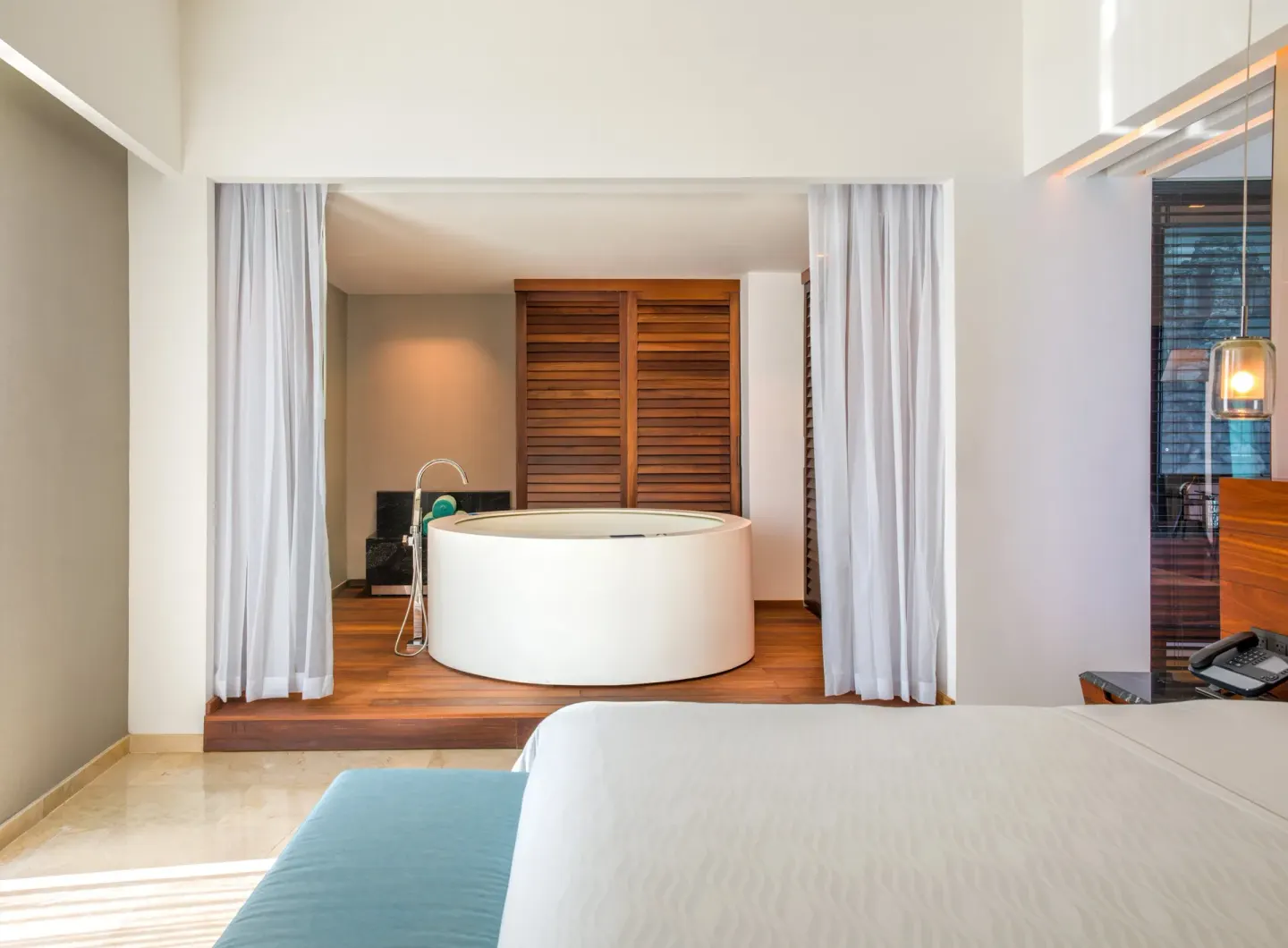 King bed and round bathtub in a guest suite at Live Aqua Cancun.