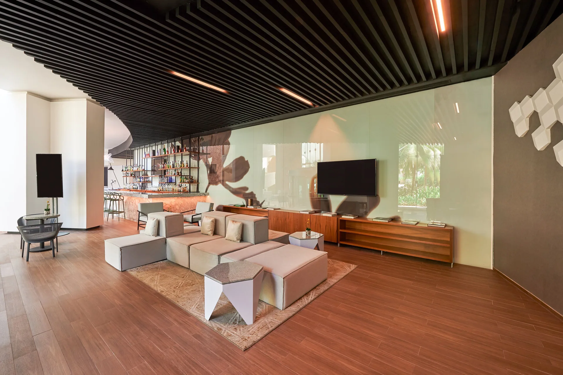 Modern lounge seating and bar area inside Live Aqua Cancun.