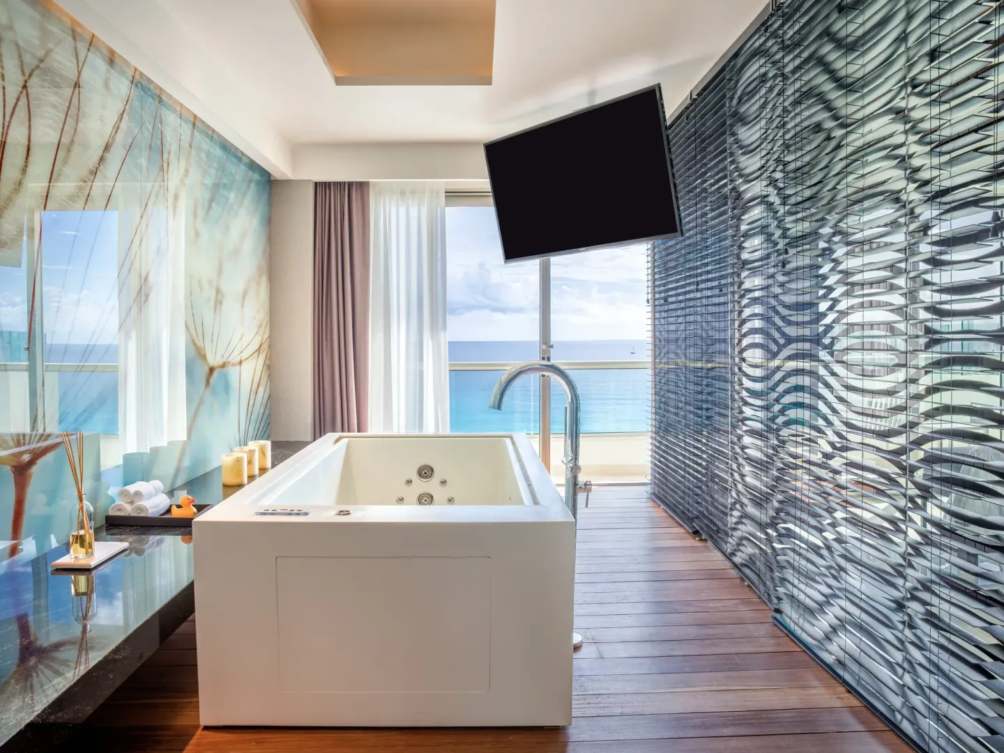 Freestanding tub by ocean-view windows in a suite at Live Aqua Cancun.