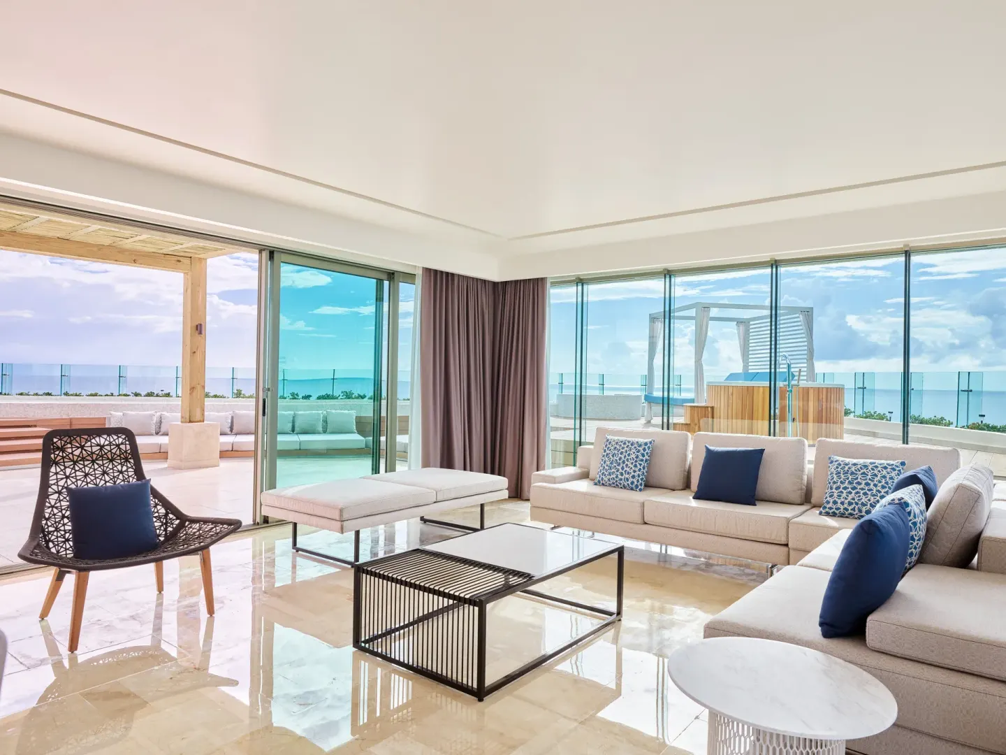 Suite lounge with sectional sofa and terrace ocean view at Live Aqua Cancun.