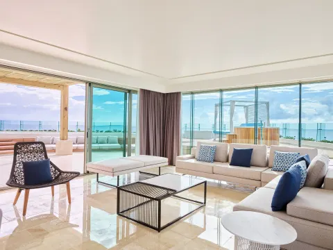 Suite lounge with sectional sofa and terrace ocean view at Live Aqua Cancun.
