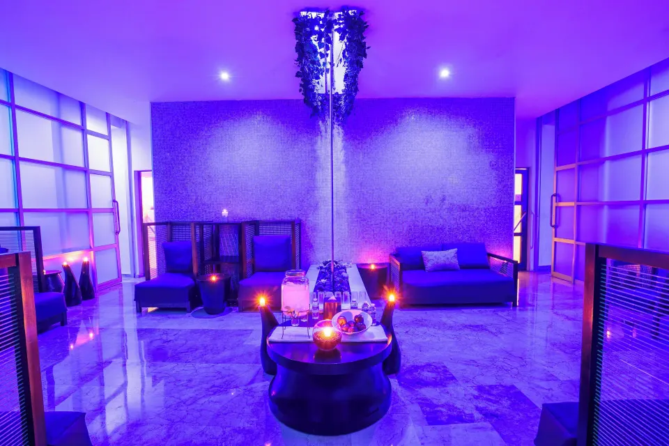 Purple-lit lounge seating and candles inside the spa at Live Aqua Cancun.
