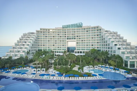 Resort exterior, pools, palms, and blue umbrellas at Live Aqua Cancun.