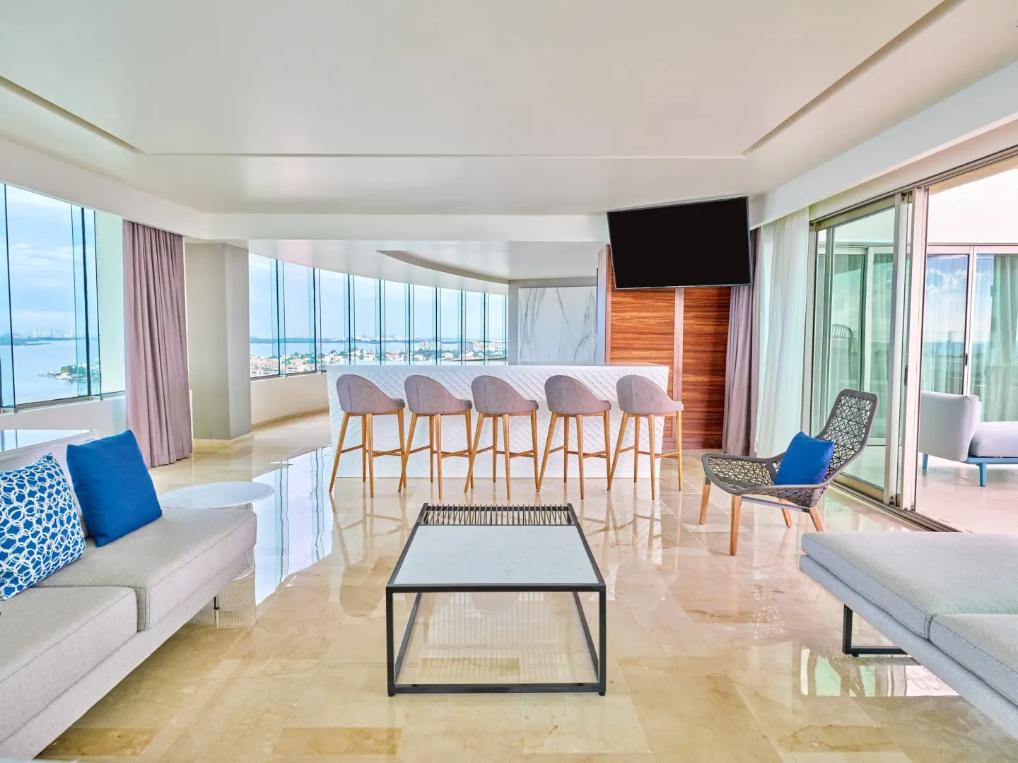 Suite living room with bar, sofas, and wide water views at Live Aqua Cancun.