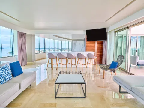 Suite living room with bar, sofas, and wide water views at Live Aqua Cancun.