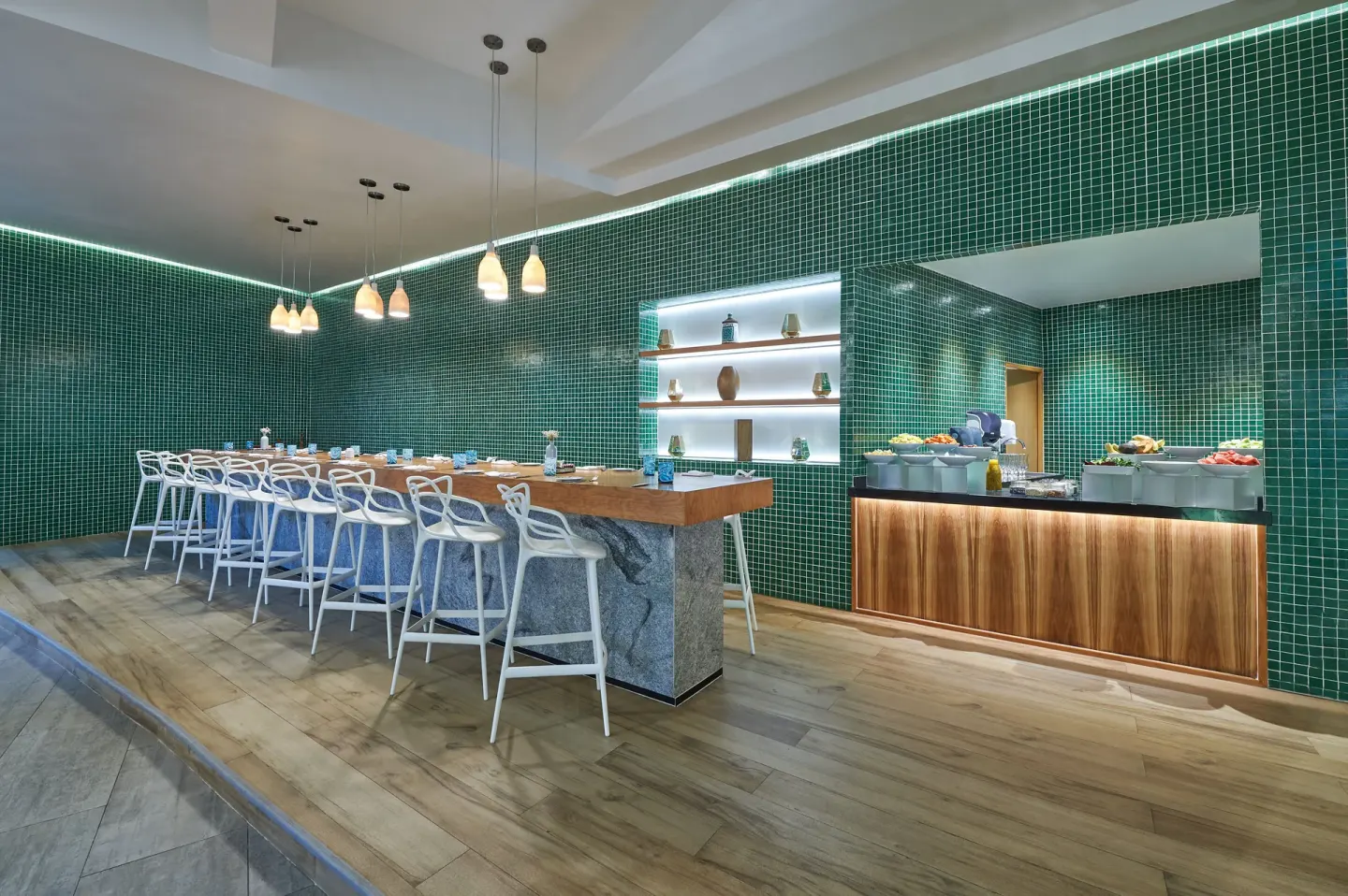 Modern sushi counter with green tile walls and white stools at Live Aqua Cancun.