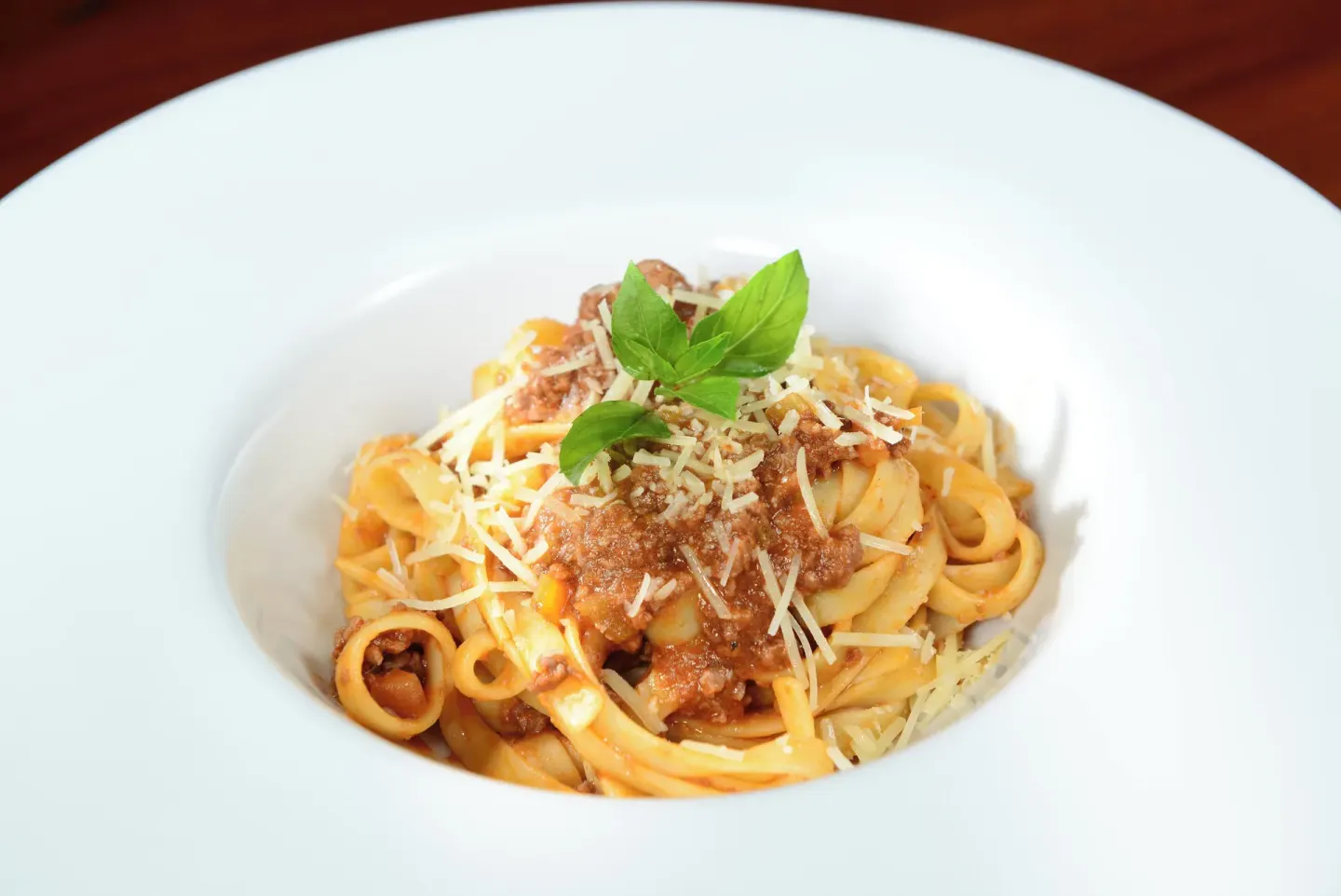 A plated pasta dish with meat sauce and basil at Live Aqua Cancun.