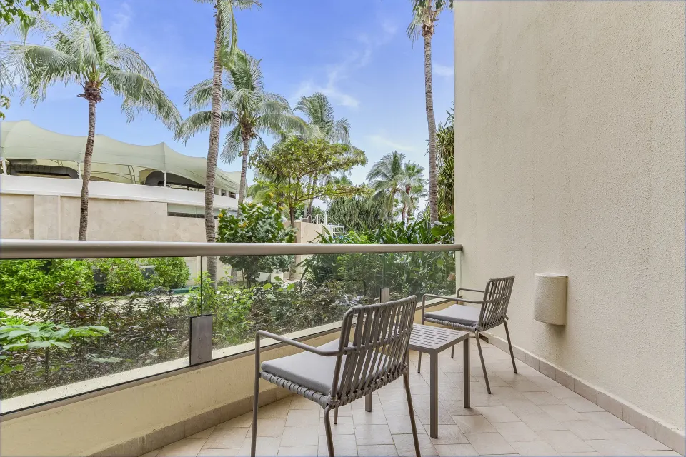 Premium Room garden-view balcony with two chairs and tropical landscaping at Live Aqua Cancun.