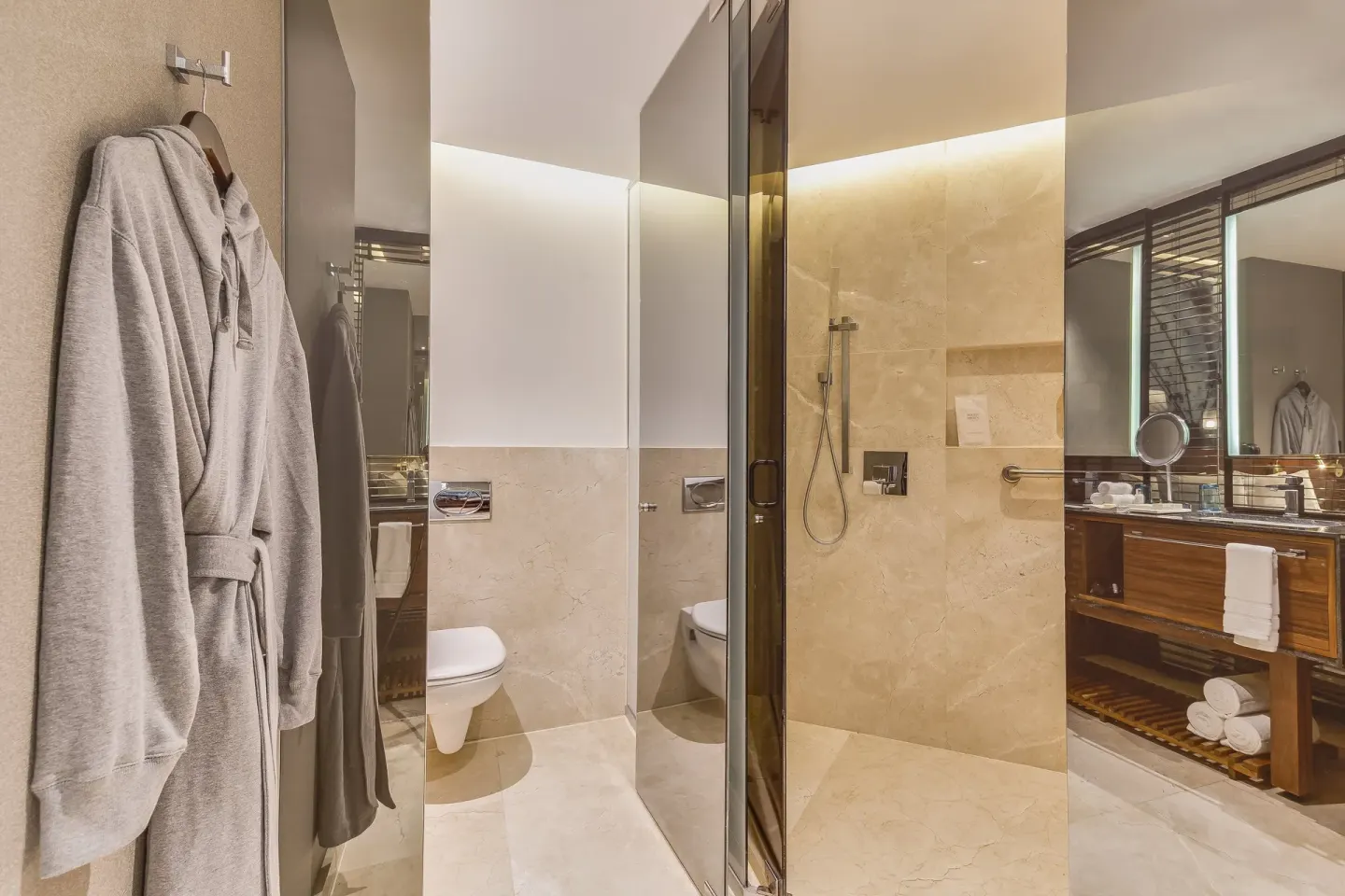 Premium Room bathroom with robes, shower, toilet, and vanity at Live Aqua Cancun.