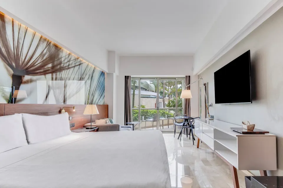 Premium Room king bed with TV, sitting area, and balcony at Live Aqua Cancun.