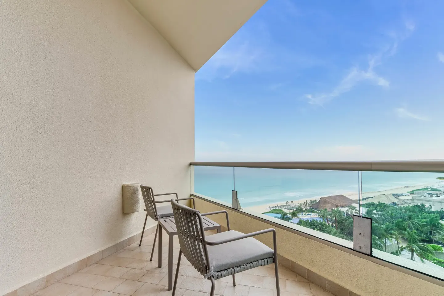 Ocean-view balcony with two chairs at Live Aqua Cancun.
