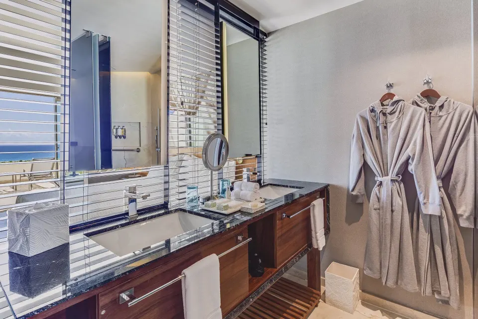 Premium Room bathroom vanity with robes and ocean visible at Live Aqua Cancun.