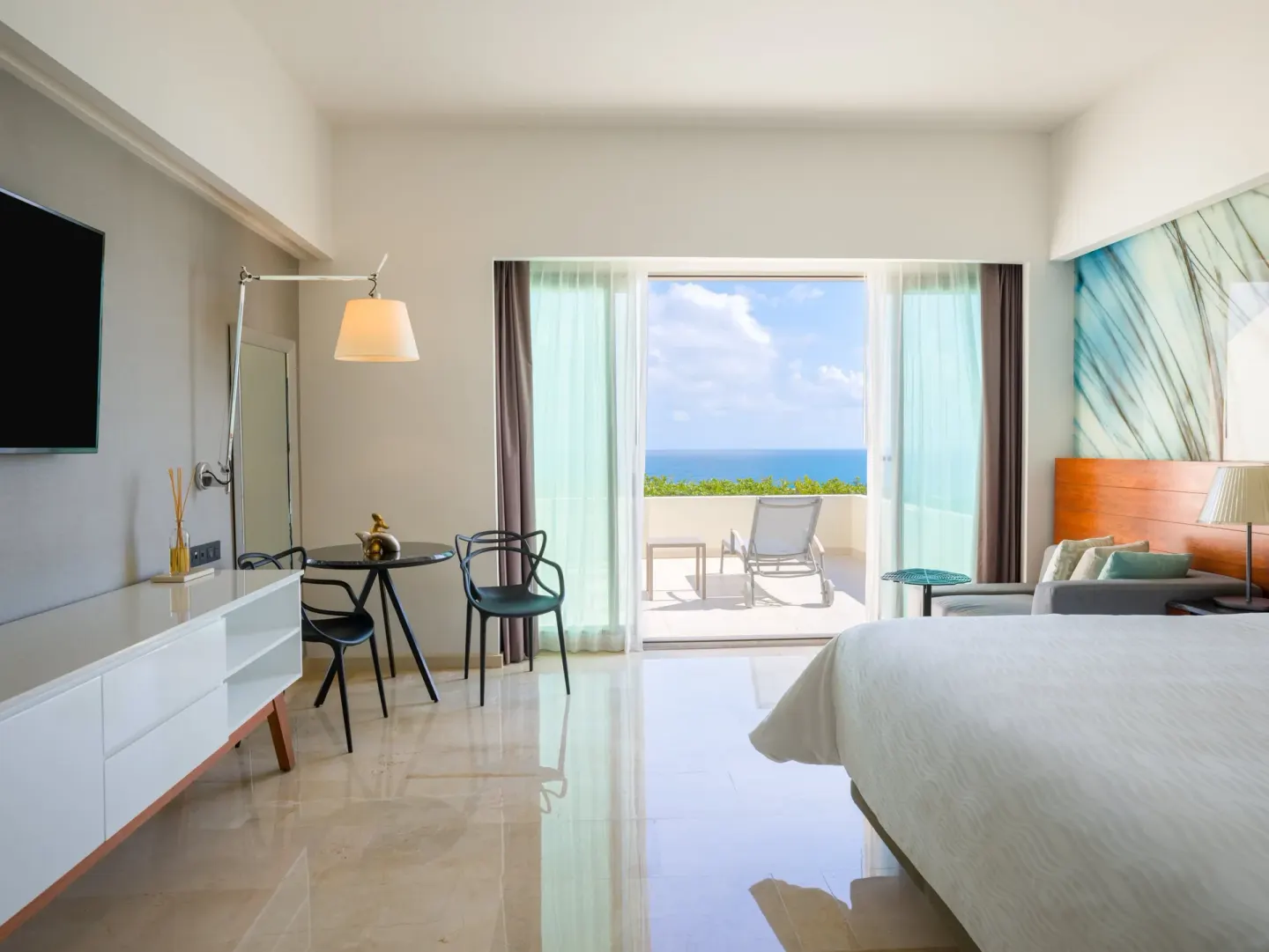 Premium Room king bed with dining table and open terrace doors at Live Aqua Cancun.