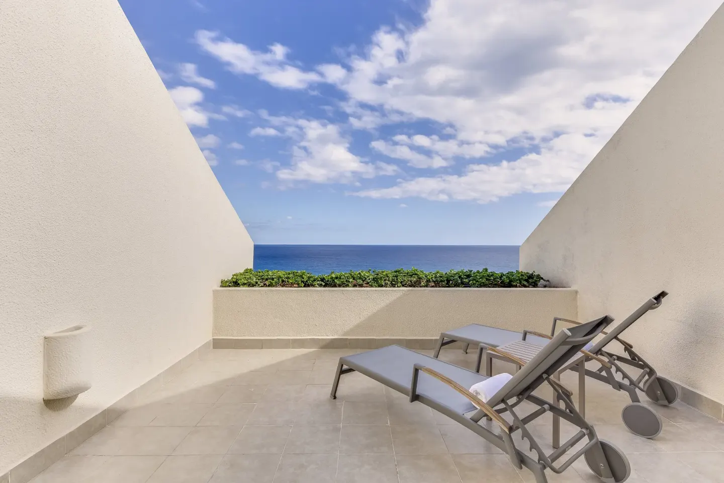 Oceanfront terrace with two lounge chairs and a sea view at Live Aqua Cancun.