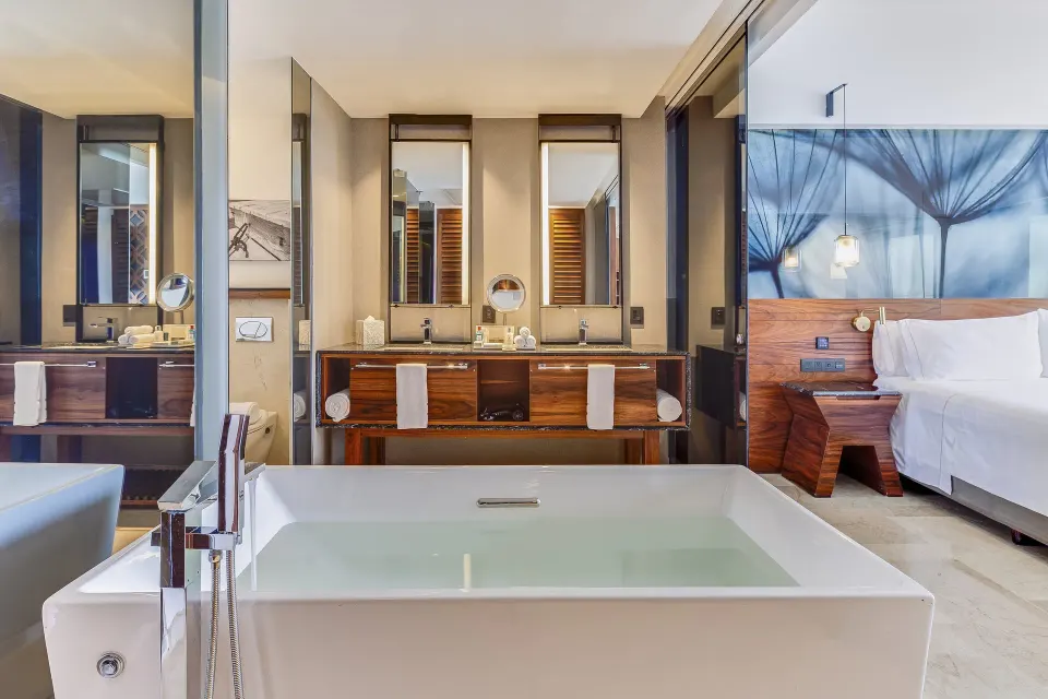 Suite bathroom with soaking tub and king bed at Live Aqua Cancun.