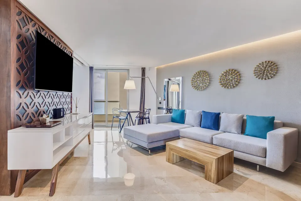 Suite Tierra living room with sofa, TV and balcony at Live Aqua Cancun.