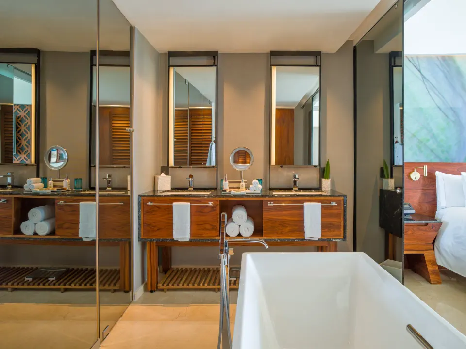Viento Suite bathroom with soaking tub, double vanity, and bedroom view at Live Aqua Cancun.