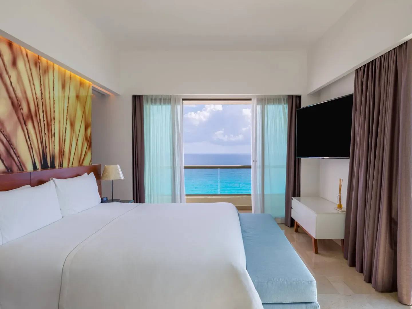 Viento Suite king bed facing an ocean-view balcony at Live Aqua Cancun.