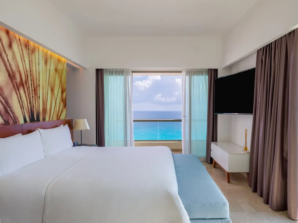 Viento Suite king bed facing an ocean-view balcony at Live Aqua Cancun.
