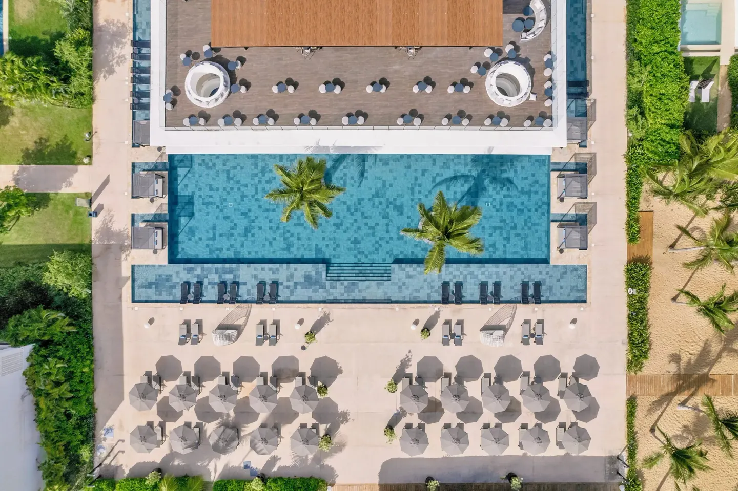 Aerial view of a pool deck beside the beach at Live Aqua Punta Cana.
