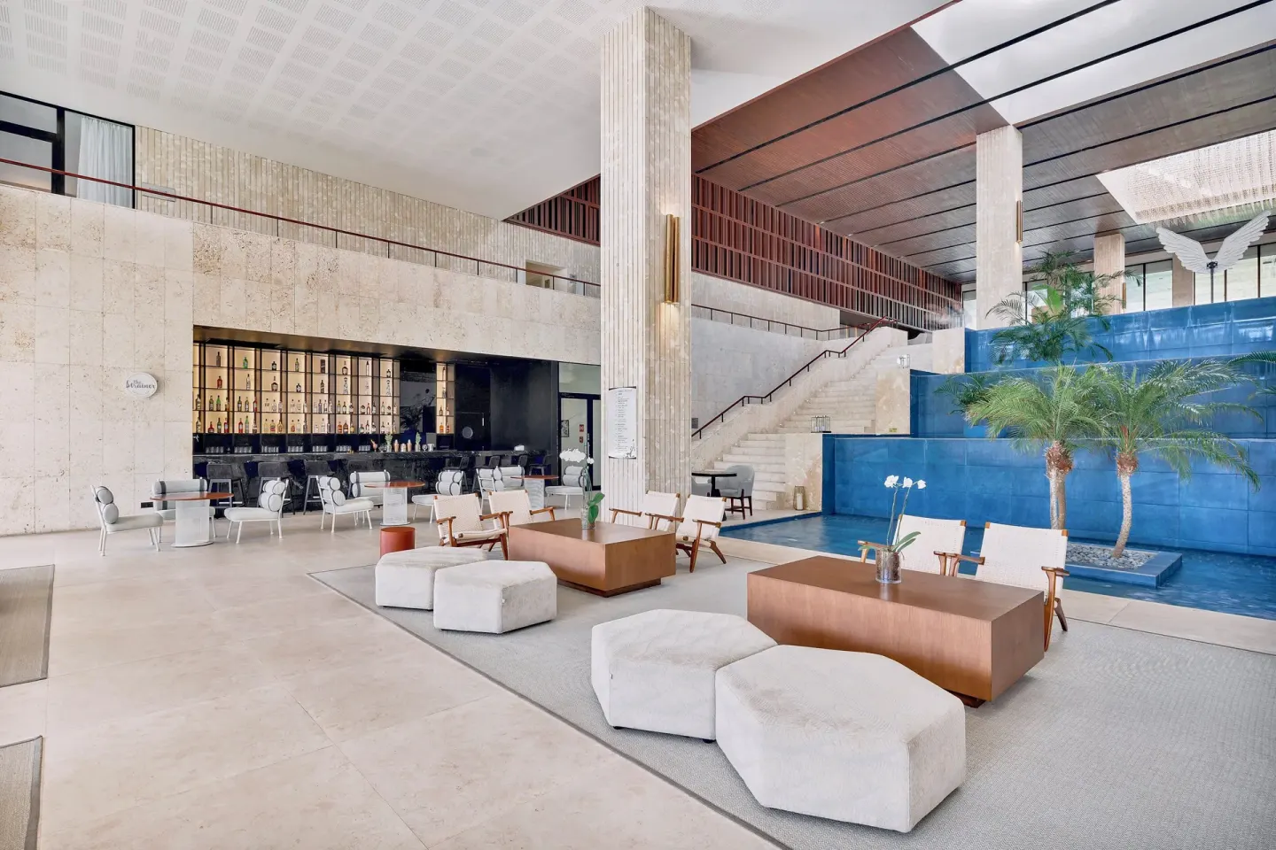 Lobby lounge with blue water feature and bar at Live Aqua Punta Cana.
