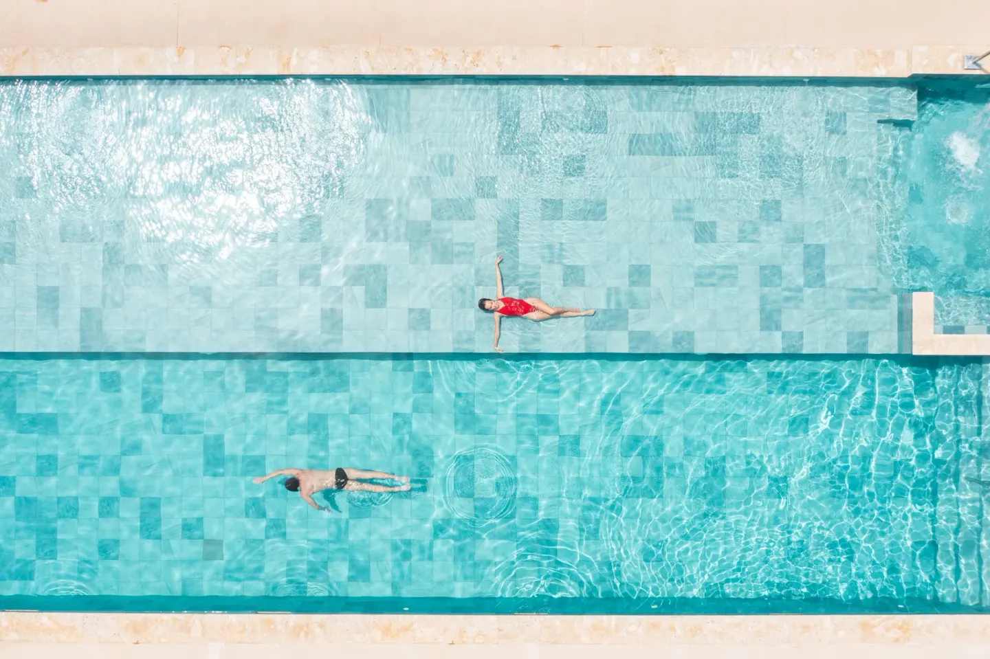 Overhead view of two swimmers in a long turquoise pool at Live Aqua Punta Cana.