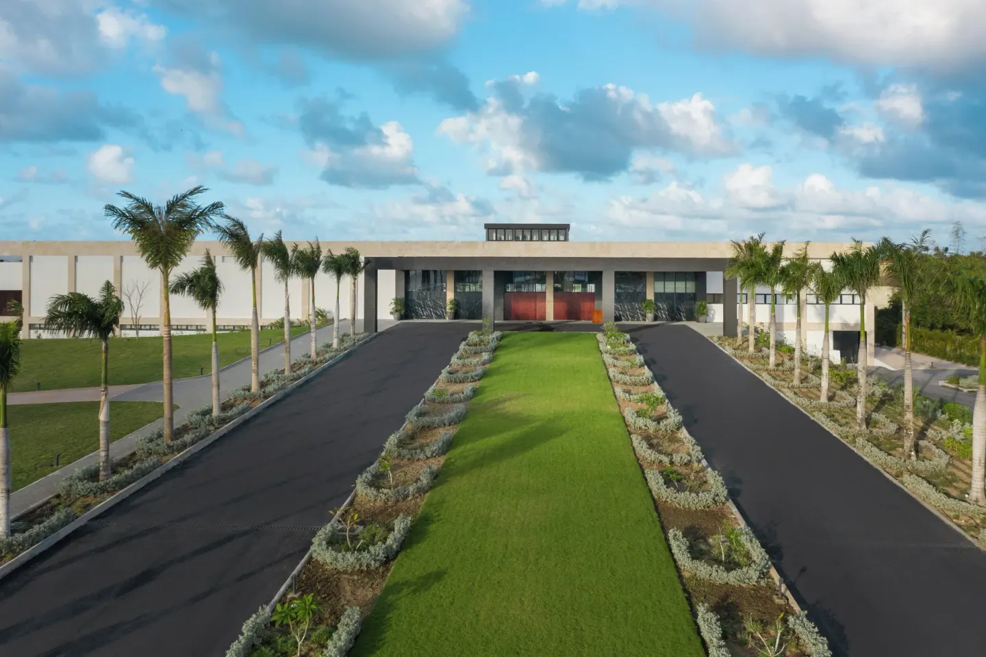 Palm-lined arrival drive leading to the lobby at Live Aqua Punta Cana.