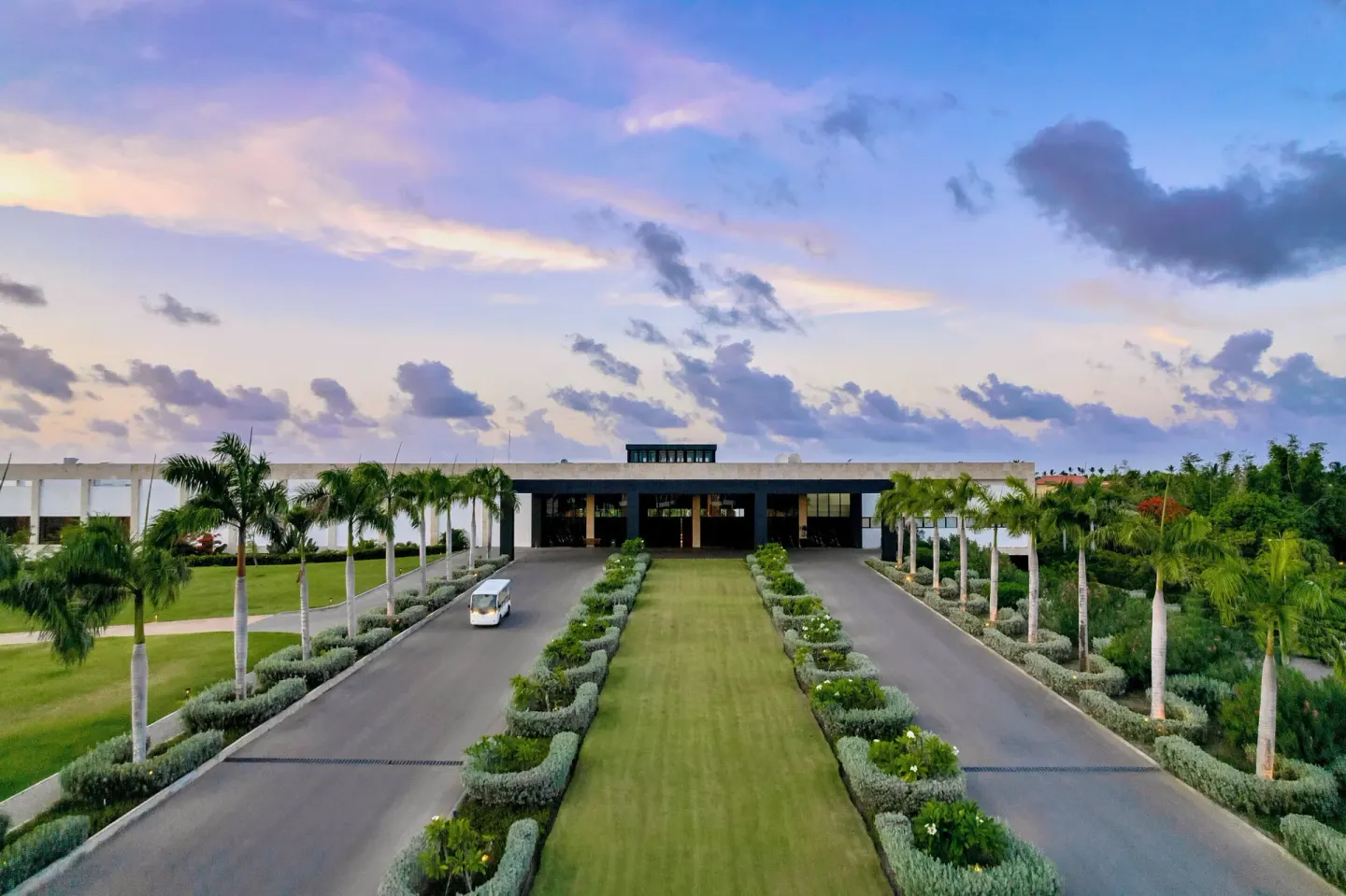 Sunset over the landscaped arrival drive at Live Aqua Punta Cana.
