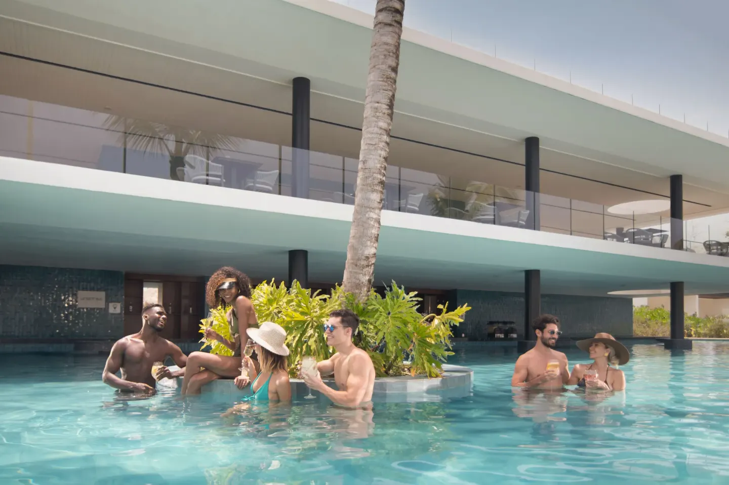 Guests stand in a swim-up pool area with drinks at Live Aqua Punta Cana.