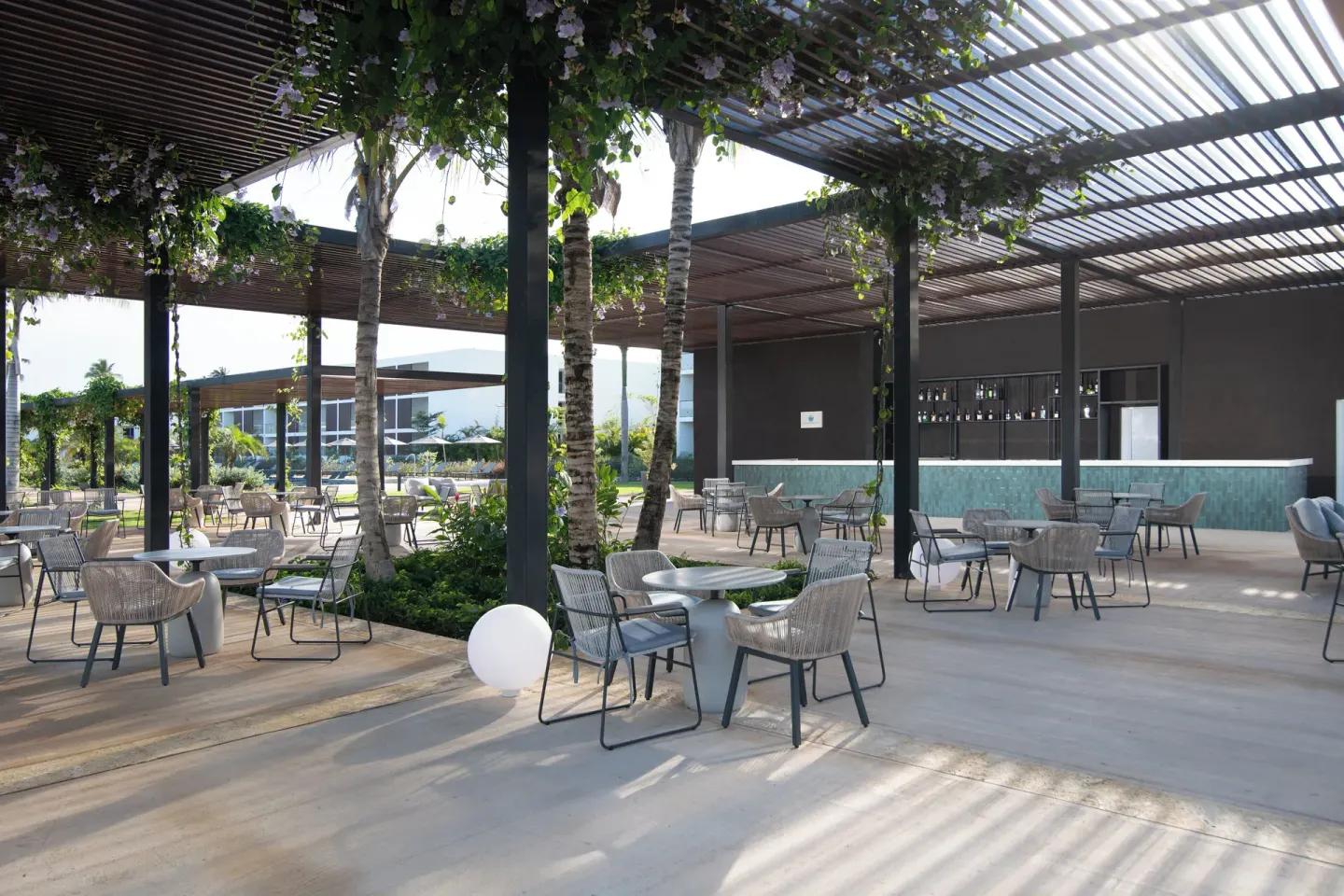 Shaded outdoor bar terrace with lounge tables at Live Aqua Punta Cana.