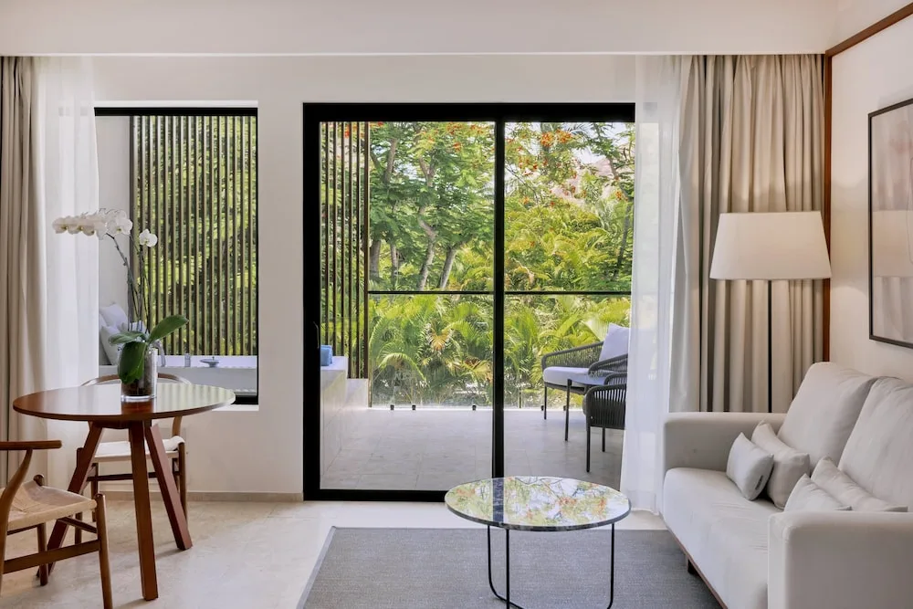Junior Suite garden-view sitting area and balcony at Live Aqua Punta Cana.
