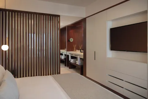 Viento Suite Ocean Front king bed, TV wall, and vanity at Live Aqua Punta Cana.