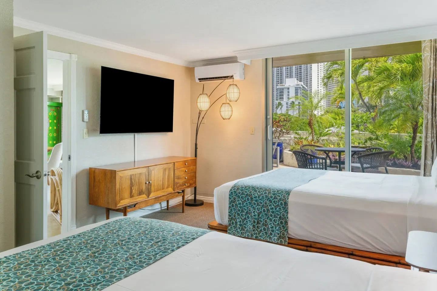 Two-bed guest room with lanai seating at Luana Waikiki Hotel & Suites.