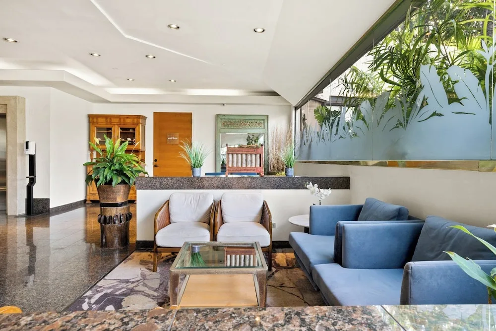 Bright lobby lounge with blue sofa seating at Luana Waikiki Hotel & Suites.