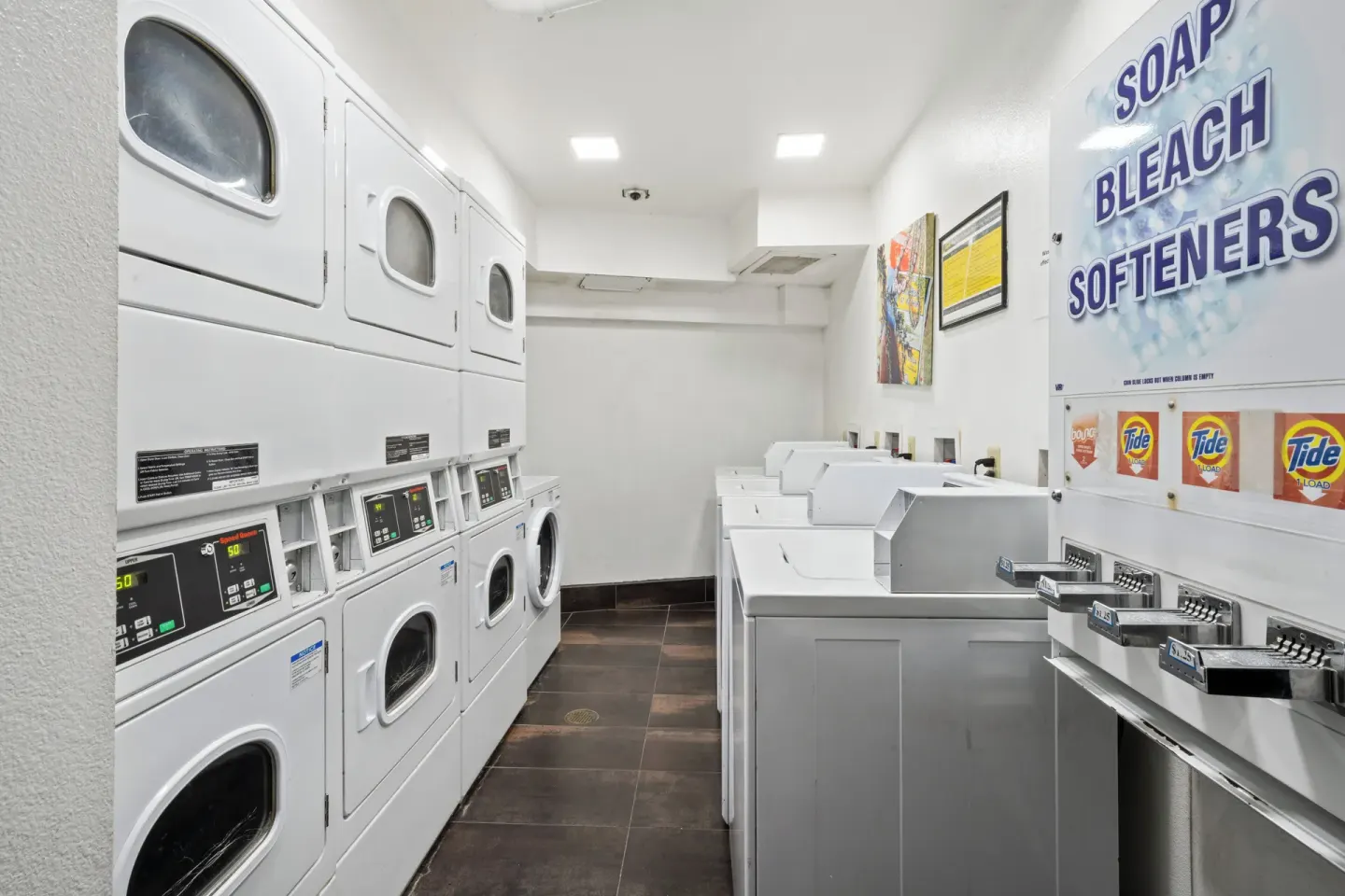 Self-service laundry room at Luana Waikiki Hotel & Suites with washers, dryers, and supplies.