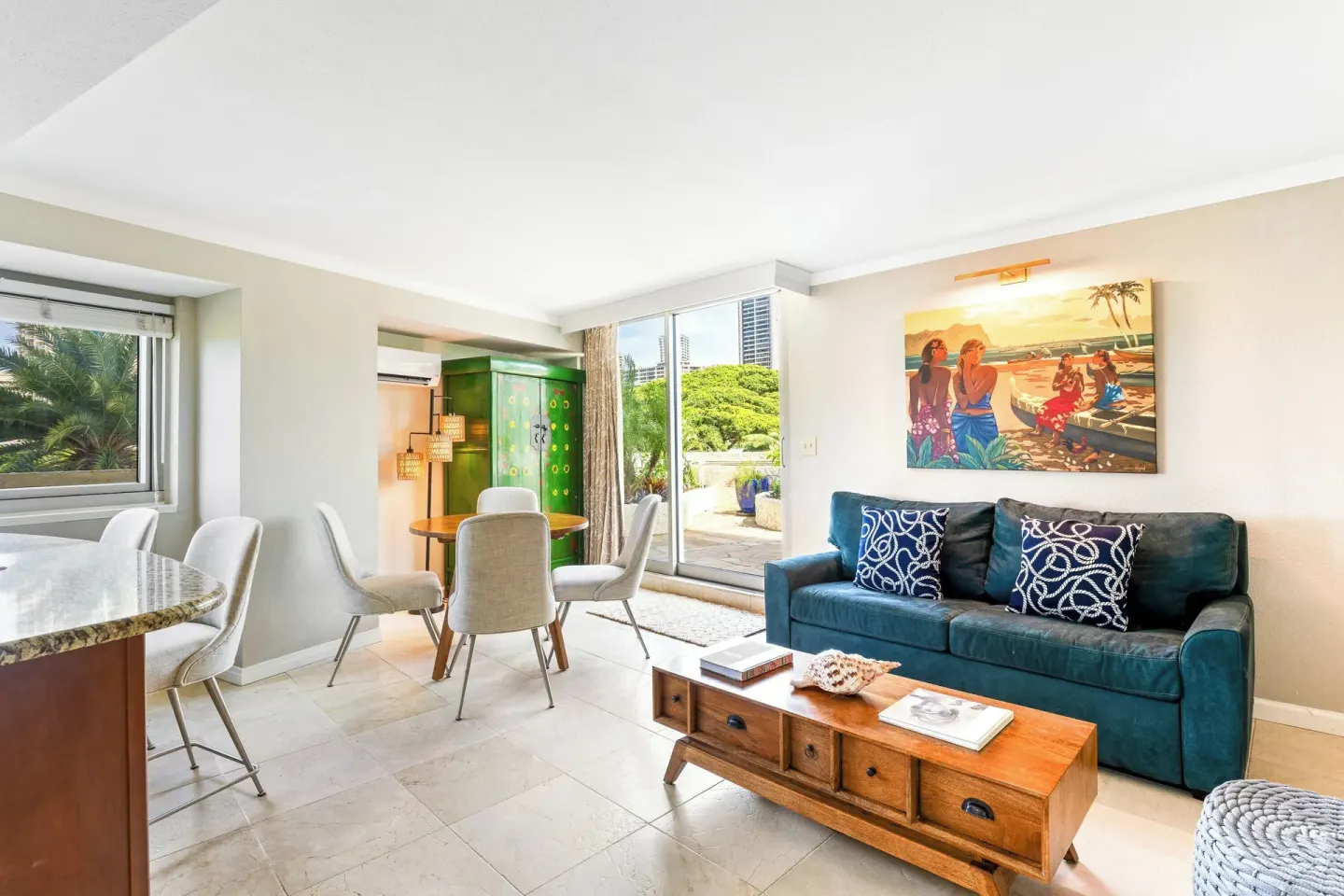 Suite living area with sofa, dining table, and lanai at Luana Waikiki Hotel & Suites.