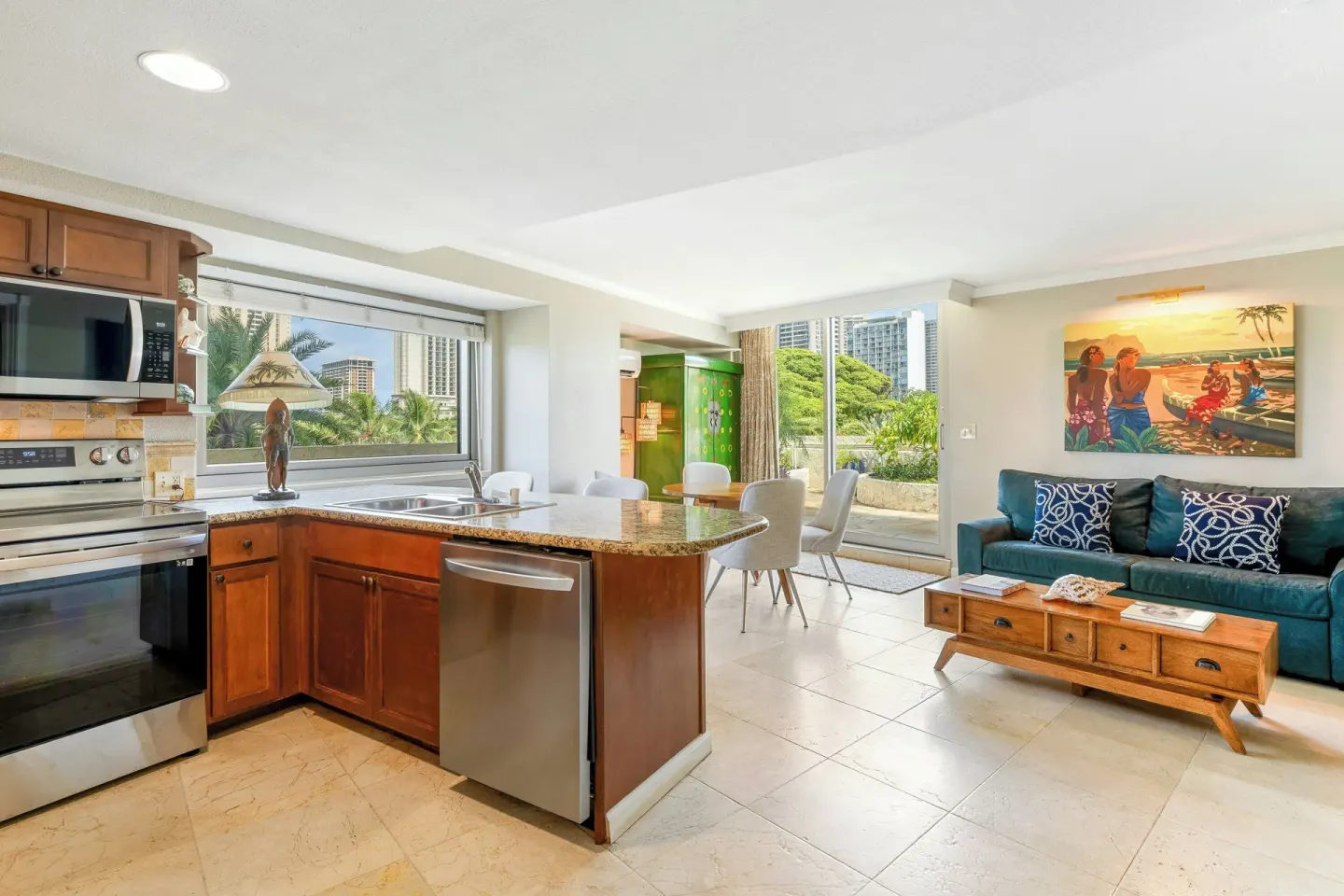 Family suite kitchen and living area at Luana Waikiki Hotel & Suites with appliances and sofa.
