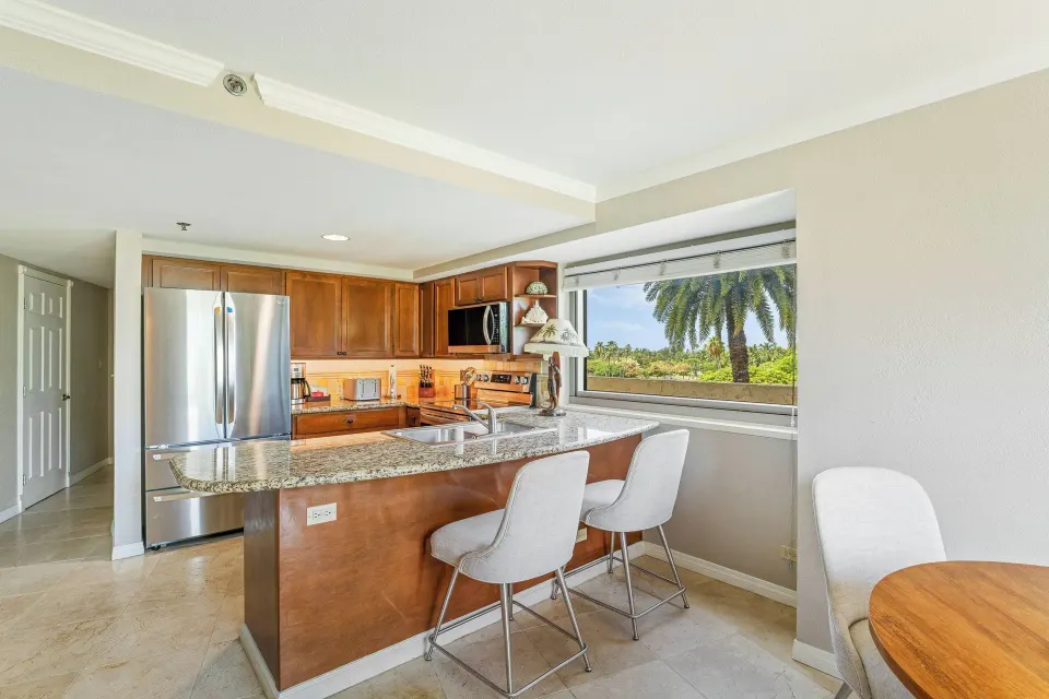 Family suite kitchen at Luana Waikiki Hotel & Suites with granite counter and stainless appliances.