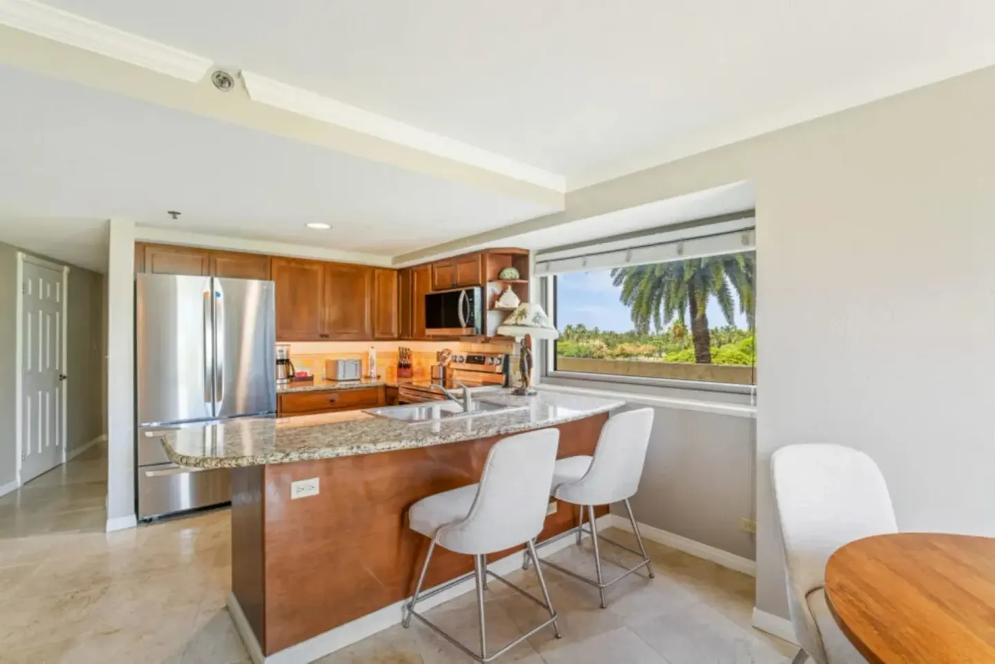 Family Suite kitchen with breakfast bar and palm view at Luana Waikiki Hotel & Suites.