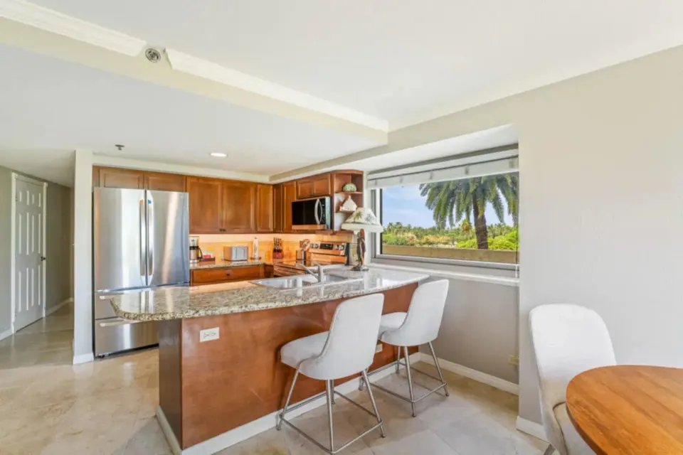 Family Suite kitchen with breakfast bar and palm view at Luana Waikiki Hotel & Suites.