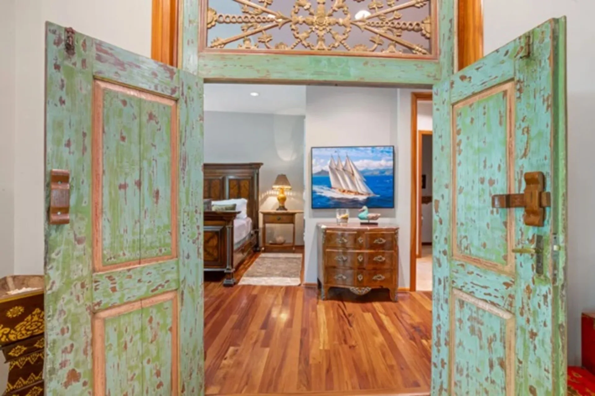 Bedroom entry with teal double doors in a luxury condo at Luana Waikiki Hotel & Suites.