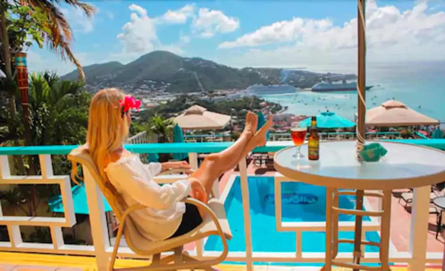 Balcony seating above the Mafolie Hotel pool with harbor and hillside views.