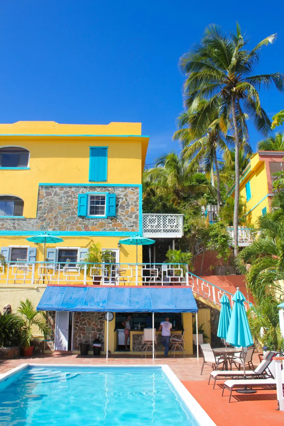 Colorful exterior buildings and pool deck at Mafolie Hotel under a clear sky.
