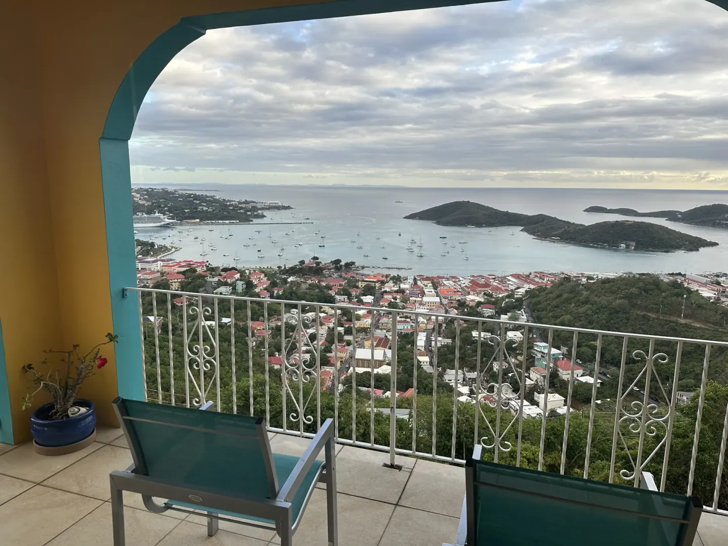 Covered balcony with chairs overlooking harbor and islands at Mafolie Hotel.