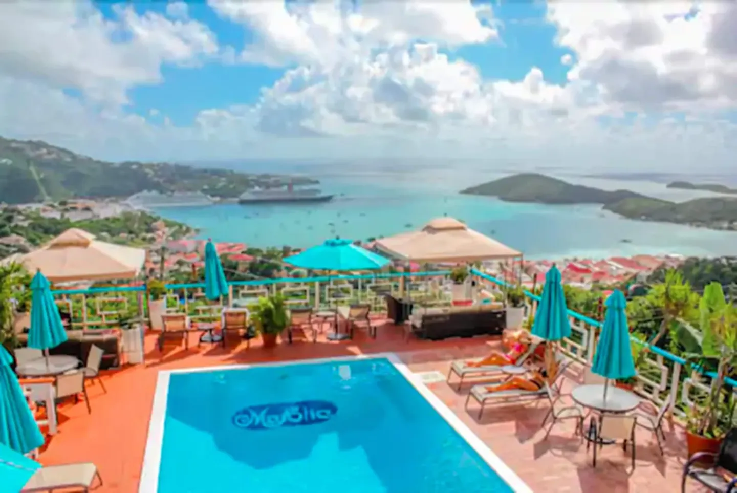 Pool terrace with umbrellas overlooking the harbor at Mafolie Hotel.